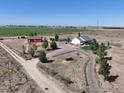 Stunning aerial view of the property featuring a charming home, red barn, and expansive land at 10691 County Road 23, Fort Lupton, CO 80621