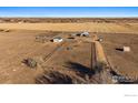 A captivating aerial view of farmland and barns on the property, showcasing the spacious landscape at 10635 County Road 24, Fort Lupton, CO 80621