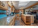 Features granite countertops, custom cabinets, a sky light, stainless appliances, and an island at 10635 County Road 24, Fort Lupton, CO 80621