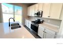 Kitchen featuring stainless appliances, quartz countertops, and white cabinetry at 16830 Mckay Dr, Mead, CO 80542