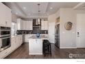 Modern kitchen with a large island, stainless steel appliances, and a stylish dark backsplash at 20411 E 53Rd Ave, Denver, CO 80249