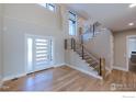 Bright foyer with modern staircase, high ceilings, and stylish front door at 9258 Niwot Hills Dr, Niwot, CO 80503