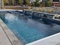 Modern pool design featuring water features and stone accents in a beautifully landscaped backyard at 9258 Niwot Hills Dr, Niwot, CO 80503