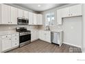 Modern kitchen with white cabinets, stainless steel appliances, and quartz countertops at 2779 Optimista Pl, Brighton, CO 80601