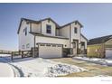 Two-story farmhouse style home with gray and white siding, stone accents, and a two-car garage at 12718 Bend Ct, Firestone, CO 80504