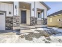 Inviting front entrance with stone accents, dark door, and a covered porch at 12718 Bend Ct, Firestone, CO 80504