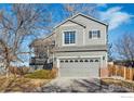 Charming two-story home with attached two car garage and mature landscaping under a sunny sky at 608 Bluegrass Dr, Longmont, CO 80503