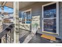 Inviting front porch with black wood floor and trim, leading to the home's entrance at 608 Bluegrass Dr, Longmont, CO 80503