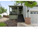 Inviting front yard with a covered porch, dark-stained stairs, and meticulous landscaping showcasing curb appeal at 608 Bluegrass Dr, Longmont, CO 80503