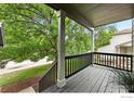Cozy front porch with sturdy pillars and a black railing, ideal for enjoying the neighborhood view at 608 Bluegrass Dr, Longmont, CO 80503
