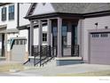 Inviting covered front porch featuring sturdy columns and iron railing on the steps at 1581 Poplar Dr, Erie, CO 80516