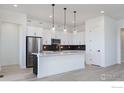 Bright white kitchen featuring a center island with a sink and modern pendant lighting at 1581 Poplar Dr, Erie, CO 80516