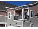 Close up of an outdoor covered balcony with black metal railings and overhead lighting at 1591 Poplar Dr, Erie, CO 80516