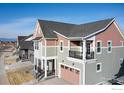 Exterior elevation showing a house with gray siding, pink accents, and a two-car garage at 1591 Poplar Dr, Erie, CO 80516