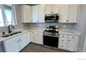 Modern kitchen featuring stainless steel appliances, white cabinets, and sleek countertops at 2263 Serenidad St, Brighton, CO 80601