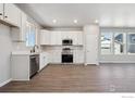 Bright kitchen with white cabinets, stainless steel appliances, and wood-look floors at 2263 Serenidad St, Brighton, CO 80601