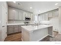 Spacious kitchen with stainless steel appliances, quartz countertops, and ample gray cabinet space at 2283 Serenidad St, Brighton, CO 80601