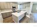 The kitchen features gray cabinets, stainless appliances, an island, white countertops and modern flooring at 2283 Serenidad St, Brighton, CO 80601