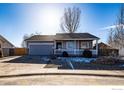 Ranch style home with a gray exterior, attached garage, and front porch at 3557 Settler Ridge Dr, Mead, CO 80542