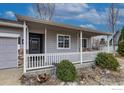 Cozy front porch with a white railing, offering a relaxing space at the entrance of this charming home at 3557 Settler Ridge Dr, Mead, CO 80542