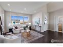 Bright and airy living room with a comfortable sofa and large windows at 4692 Clear Creek Dr, Firestone, CO 80504