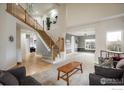 Spacious living room with hardwood floors, high ceilings, and a staircase at 1366 Teton Pt, Lafayette, CO 80026