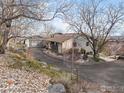 Gray home with stone accents, a long driveway, and landscaping at 230 Cactus Ct, Boulder, CO 80304