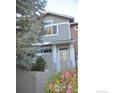 Charming two-story home features light-colored siding and a well-manicured front yard with a variety of flowering bushes at 4110 Riley Dr, Longmont, CO 80503