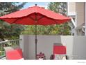 Red umbrella and patio furniture with red cushions at 4110 Riley Dr, Longmont, CO 80503