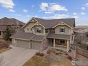 Stunning two-story home featuring a three-car garage and charming front porch details at 7690 S Blackstone Pkwy, Aurora, CO 80016