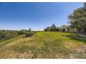 Expansive green lawn leading to a yellow house with mature trees under a clear blue sky at 34 S Raleigh St, Denver, CO 80219