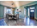 Formal dining area featuring a dark wood table and modern chandelier at 6918 Purdue Ave, Firestone, CO 80504