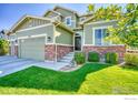 Green-sided house with a three-car garage and well-manicured lawn at 6918 Purdue Ave, Firestone, CO 80504