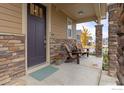 Inviting front porch with two chairs and stone accents at 1127 Highlands Dr, Erie, CO 80516