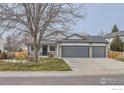 Ranch-style home with gray three-car garage and landscaped front yard at 1127 Red Oak Dr, Longmont, CO 80504