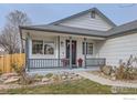 Charming front porch with gray railing and red planters at 1127 Red Oak Dr, Longmont, CO 80504