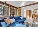 Inviting living room features exposed wood beams, built-in shelving, and a comfortable blue sectional sofa at 160 Bristlecone Way, Boulder, CO 80304