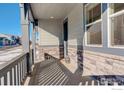 Covered front porch with stone accents and a view of the neighborhood at 1860 Miranda Rd, Erie, CO 80516