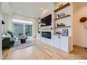 Bright living room with a fireplace, flatscreen TV and floating shelves at 1998 Foxtail Ln # B, Lafayette, CO 80026