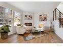 Cozy living room featuring a modern fireplace, large windows, and hardwood floors at 3040 W 107Th Pl # B, Westminster, CO 80031