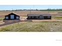 Aerial view showing a house, detached garage, and surrounding land at 17910 Slavin Way, Platteville, CO 80651