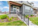 Front entrance of townhome with steps, railing, and landscaping at 317 Gray Jay Ct, Berthoud, CO 80513