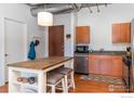 Eat-in kitchen with island, wood cabinets, and stainless steel appliances at 3701 Arapahoe Ave # 317, Boulder, CO 80303