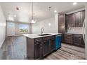 Modern kitchen features an island, stainless steel appliances, and blue dishwasher at 410 High Point Dr # 103, Longmont, CO 80504