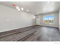 Bright living room with hardwood floors and large window at 410 High Point Dr # 103, Longmont, CO 80504
