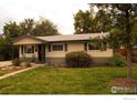 Charming single story home with mature trees, a well-maintained lawn, and inviting curb appeal at 6213 Gray St, Arvada, CO 80003