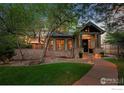 Stunning home at dusk featuring stone accents, landscape lighting, and covered front porch at 820 6Th St, Boulder, CO 80302