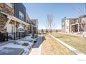 Modern townhomes featuring metal and stone accents, front yard area with walkway, and mountain views at 821 Robert St, Longmont, CO 80503