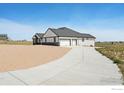 House exterior showcasing a three-car garage and a long driveway at 16474 Essex S Rd, Platteville, CO 80651