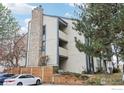 Tan multi-unit building with stone accents and wood fencing at 497 S Memphis Way # 10, Aurora, CO 80017